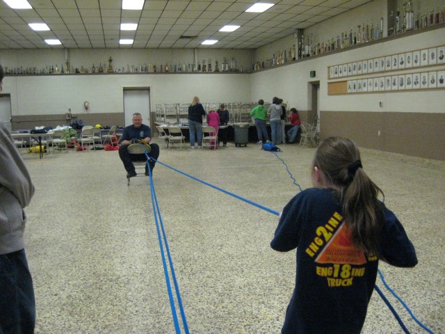 Ropes and Knots, 2008.  A little person pulling a huge weight using the Pulley System.