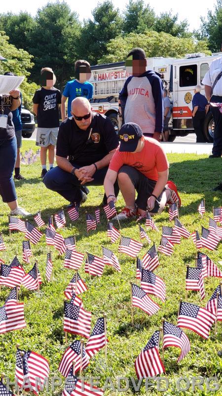 Student Ryan Carroll places a flag in remembrance of the victims of 9/11. He was assisted by his father Assistant Chief Jeff Carroll. 